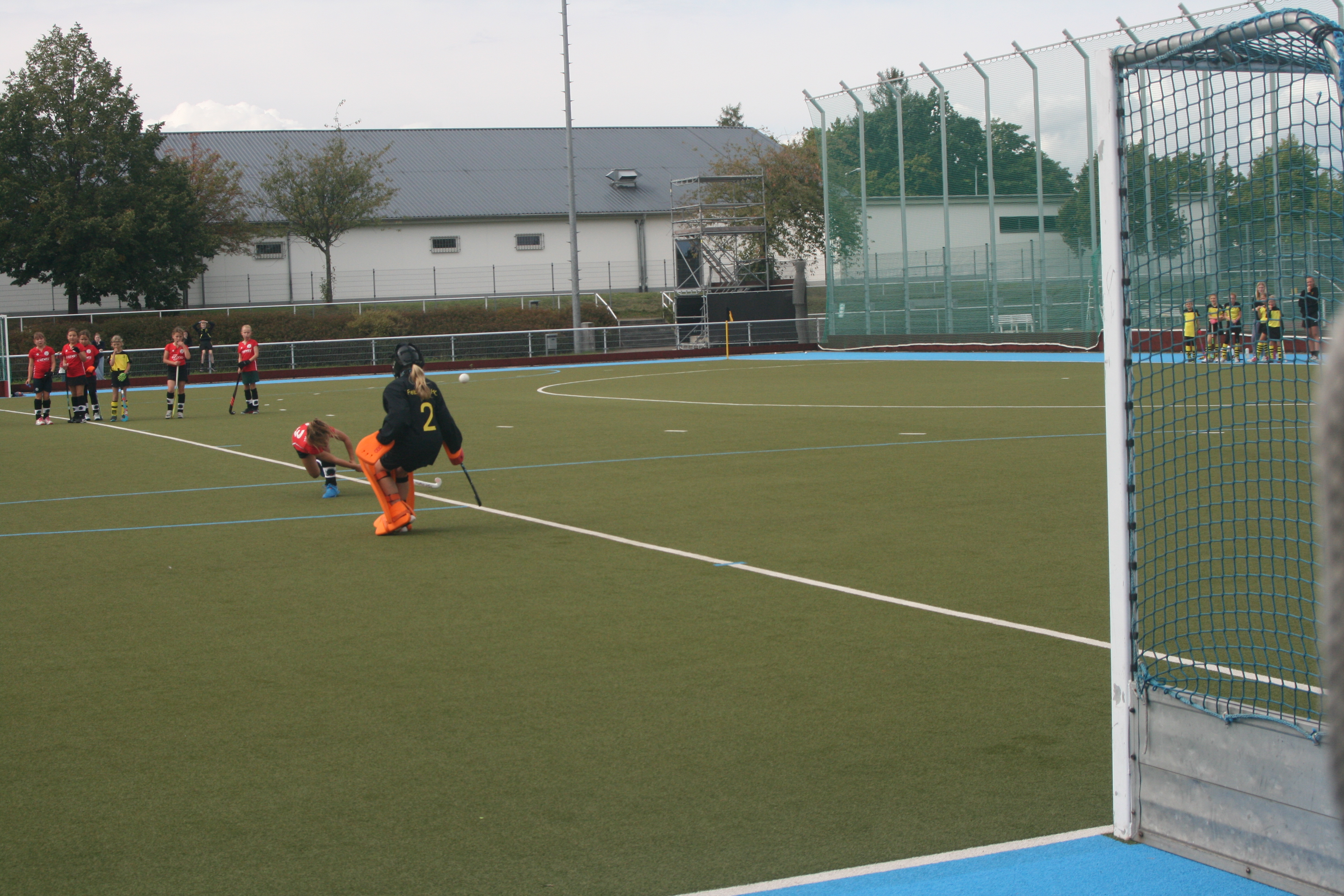 Torhüter auf Hockeyfeld vor leerem Tor.
